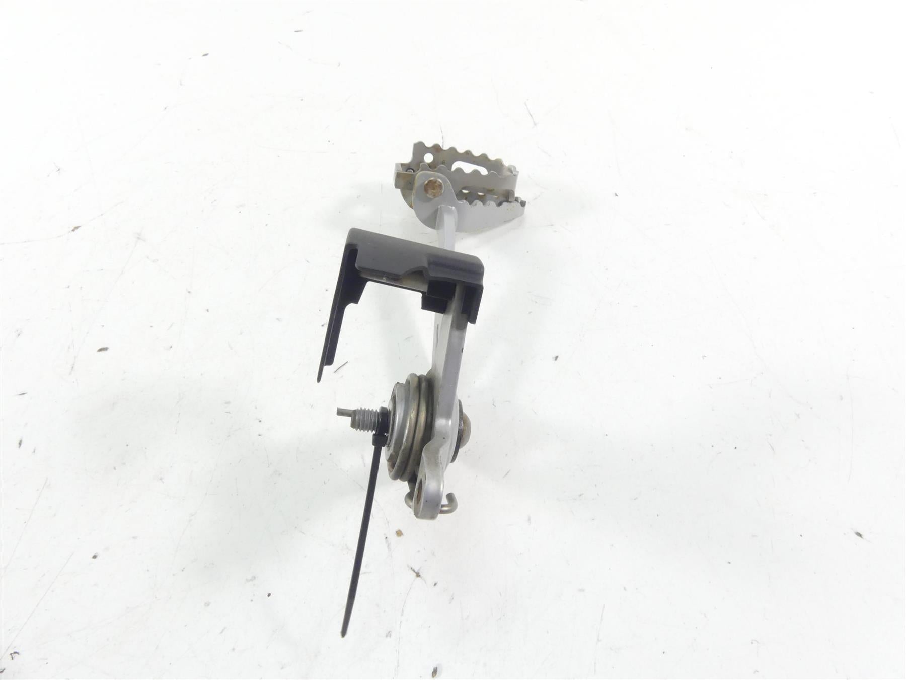Used motorcycle foot peg assembly with bracket and spring, available at Mototech271