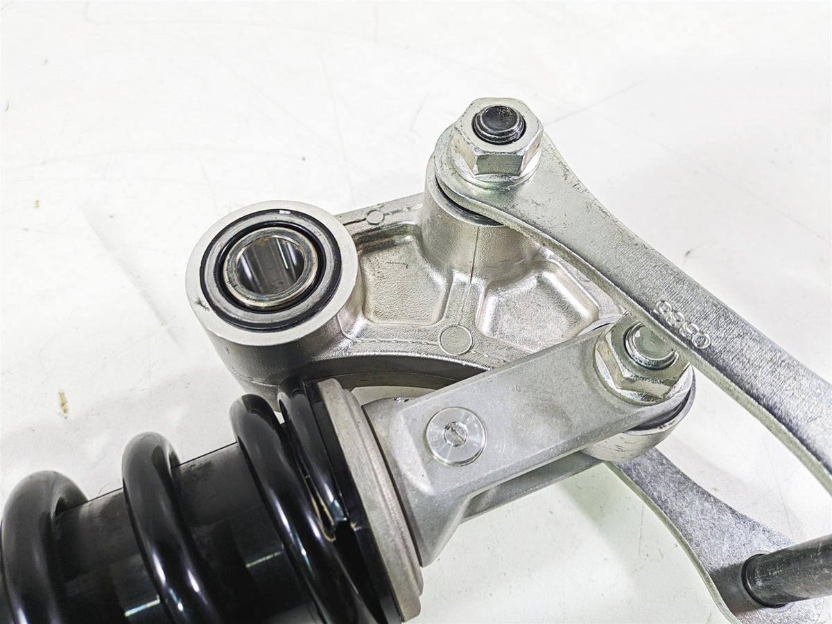Used motorcycle shock absorber and linkage with bearings on white background, available at Mototech271