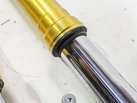 Close-up of a used gold motorcycle front fork suspension part on white background, available at Mototech271