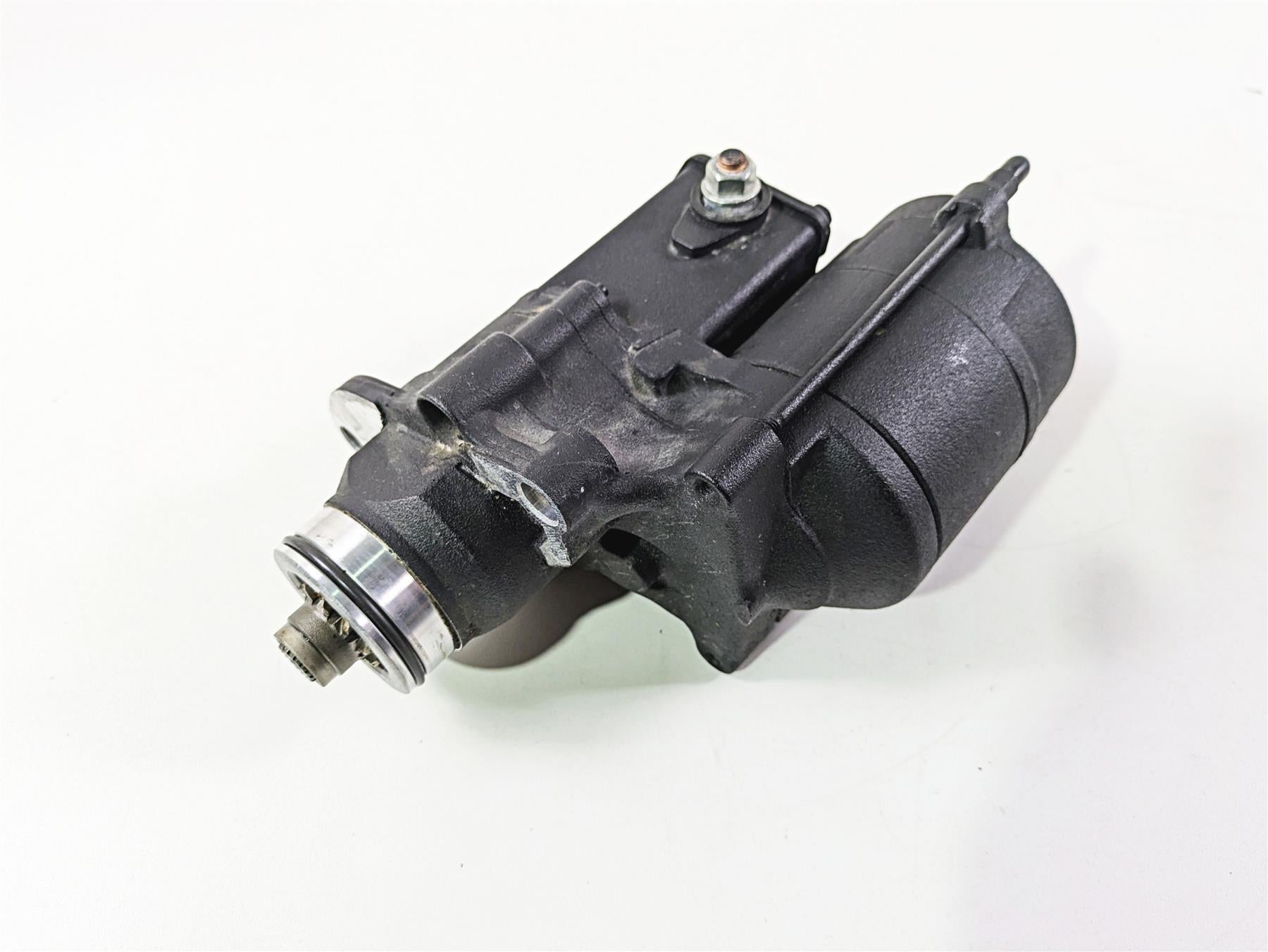 Used black motorcycle starter motor part on white background, available at Mototech271