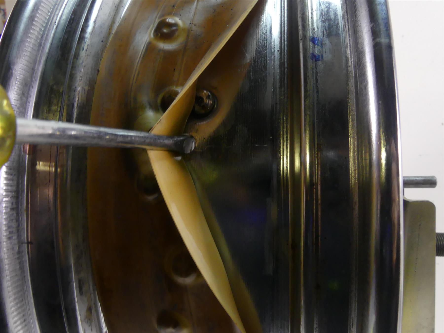 Close-up of motorcycle wheel rim with rim strip and screwdriver, available at Mototech271