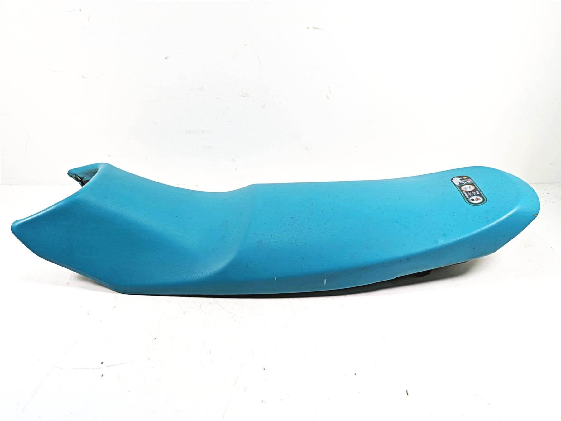 Blue used motorcycle seat part with label on top, available at Mototech271