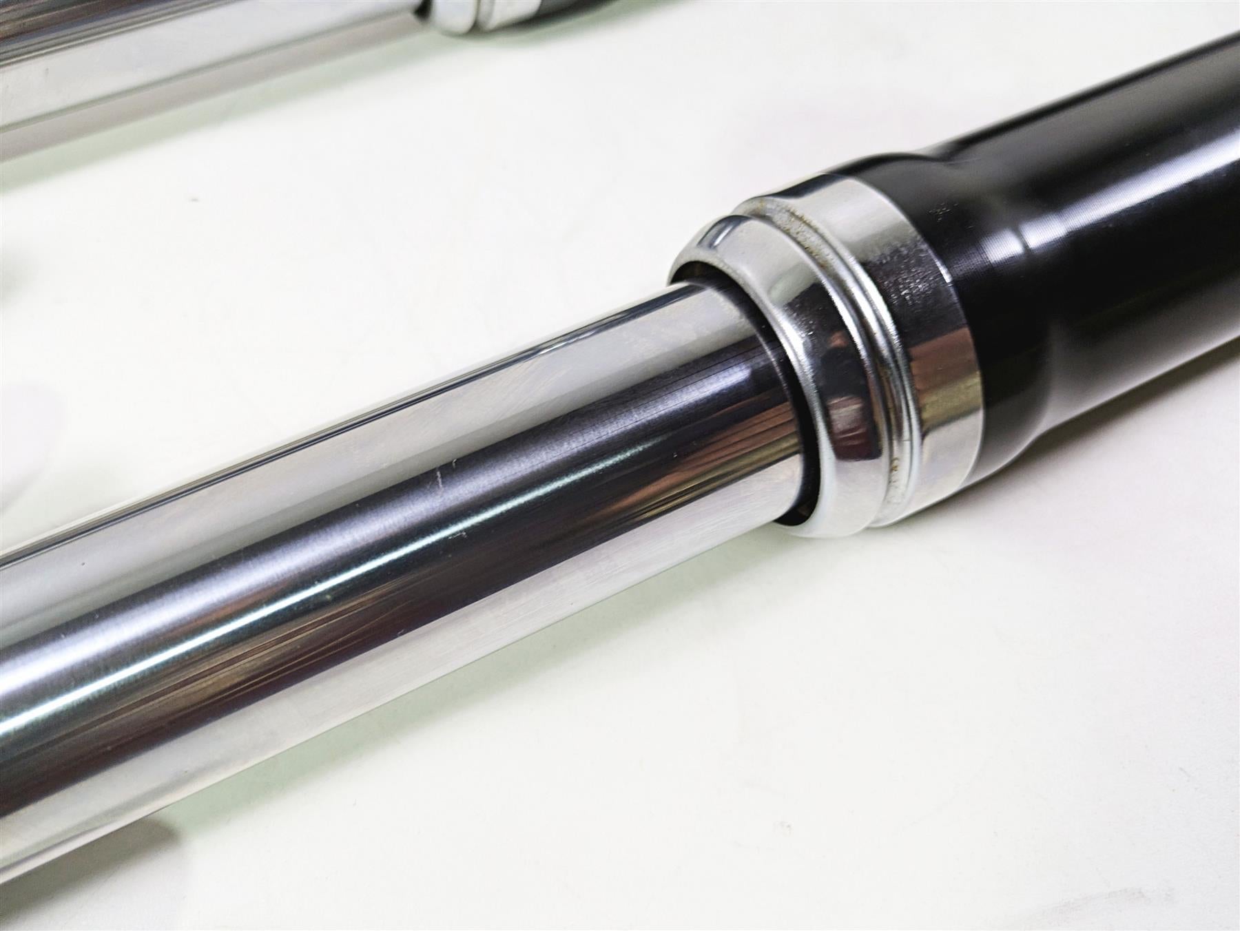 Close-up of used motorcycle front fork suspension part, chrome and black, available at Mototech271