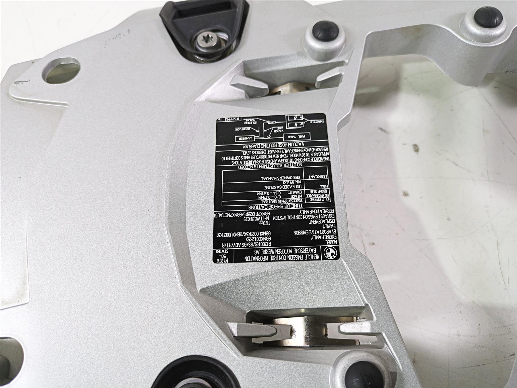 Silver motorcycle part with black label and bolts on white background, available at Mototech271