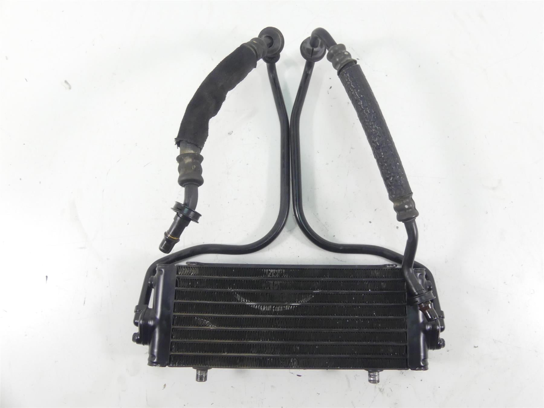 Used motorcycle oil cooler with attached hoses, black metal, available at Mototech271