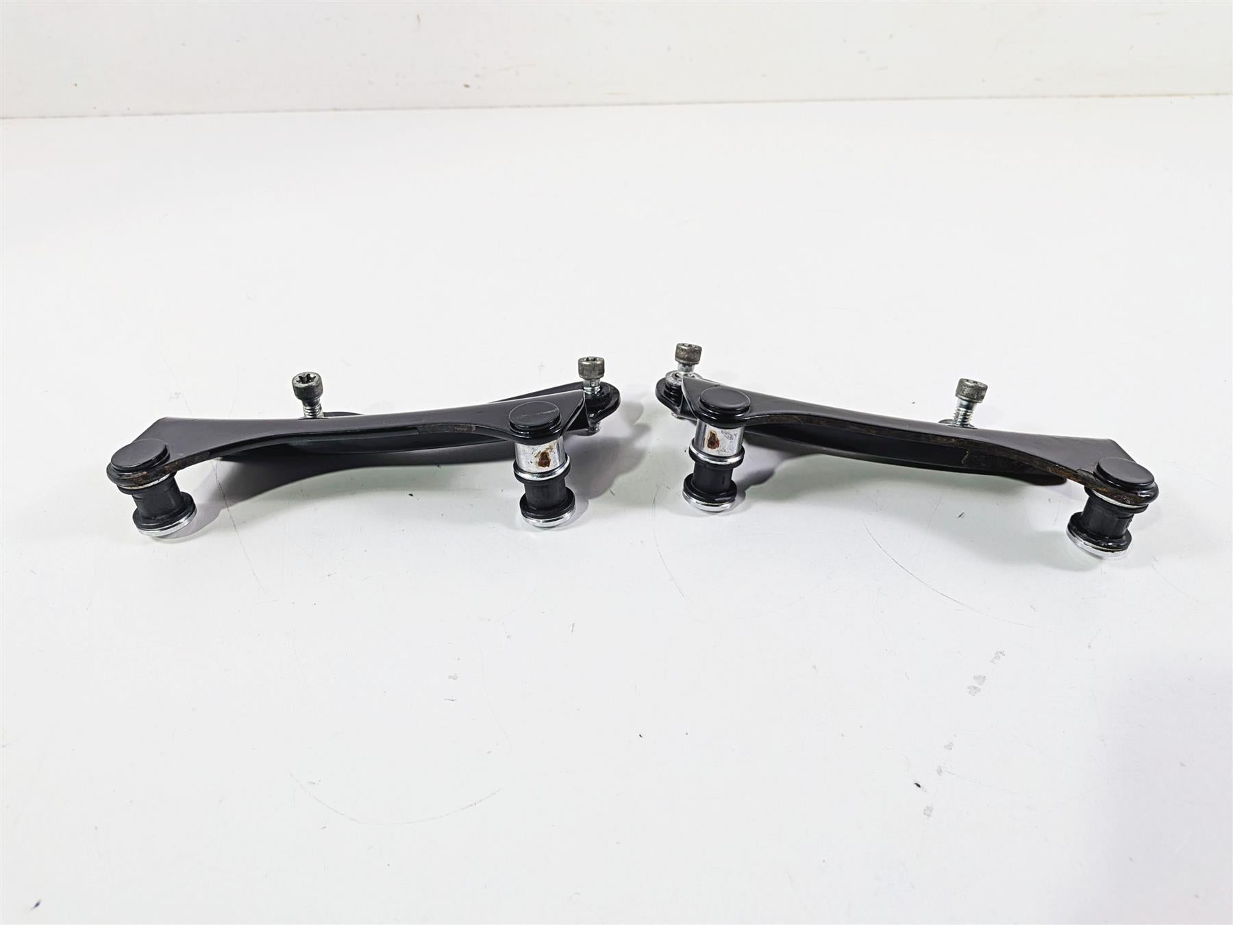 Pair of used motorcycle control arms with bolts on white background, available at Mototech271
