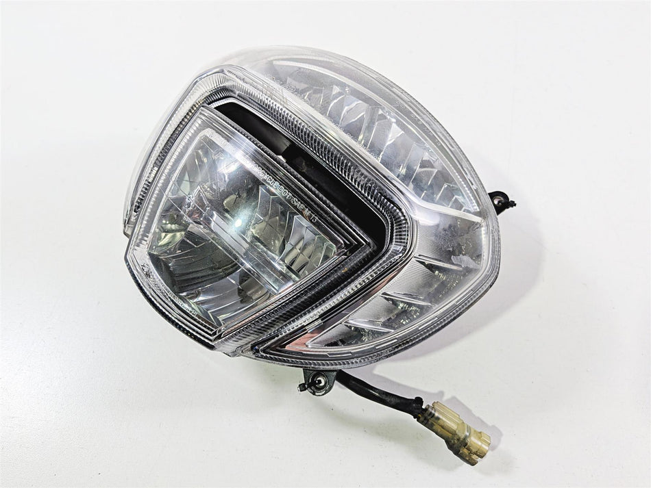 Used motorcycle headlight assembly with clear lens and wiring, shown on white background