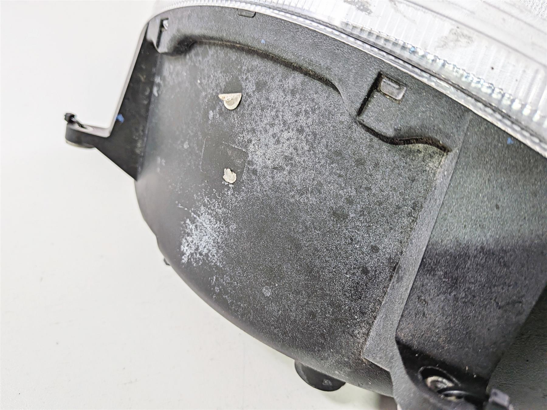 Close-up of used motorcycle headlight housing showing wear and surface scuffs