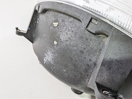 Close-up of used motorcycle headlight housing showing wear and surface scuffs