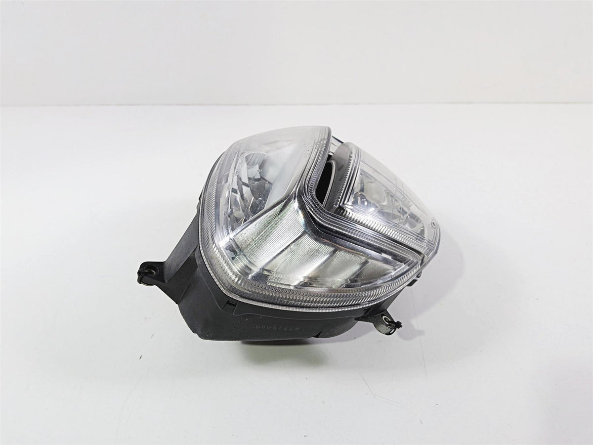 used motorcycle headlight assembly with clear lens and black housing on white background