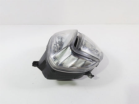 used motorcycle headlight assembly with clear lens and black housing on white background